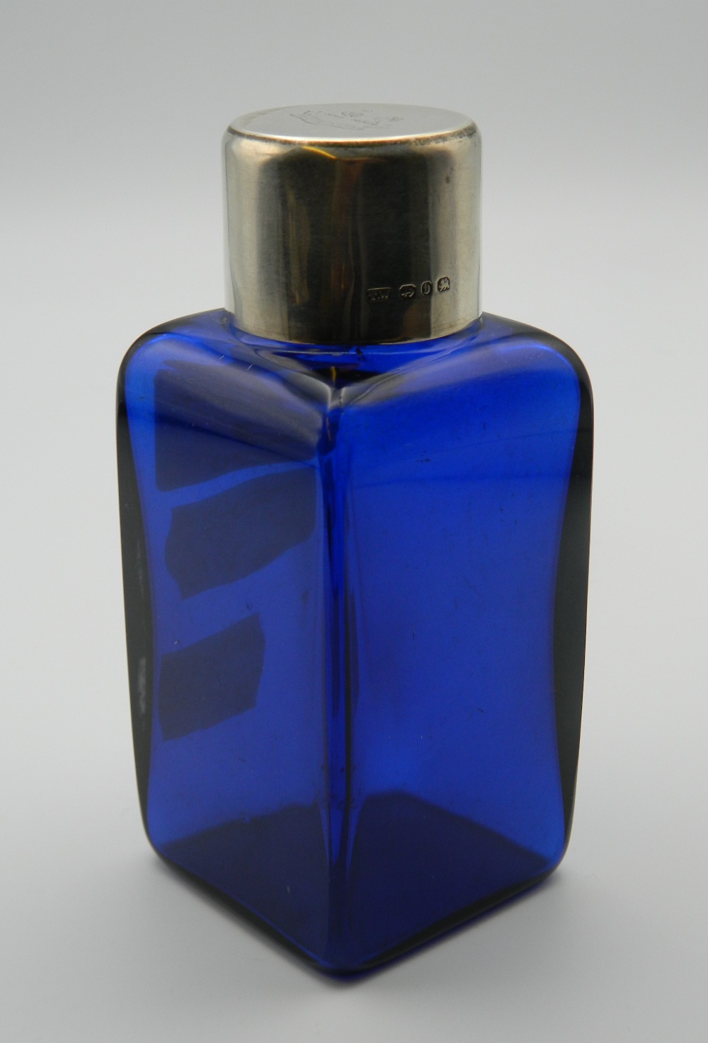 A silver topped blue glass scent bottle