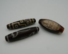 Three agate dzi beads. The largest 5.5 cm long.