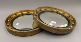 A pair of gilt framed convex wall glasses. 41.5 cm diameter.