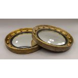 A pair of gilt framed convex wall glasses. 41.5 cm diameter.