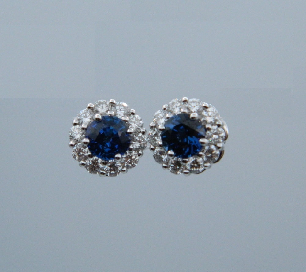 A pair of 18 ct white gold quality diamond and sapphire halo earrings.