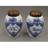 A pair of Crown Devon blue and white porcelain tobacco jars with turned wooden covers. 27.5 cm high.