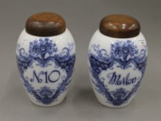 A pair of Crown Devon blue and white porcelain tobacco jars with turned wooden covers. 27.5 cm high.