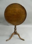 A 19th century oak and mahogany tilt-top tripod table. 53.5 cm diameter.