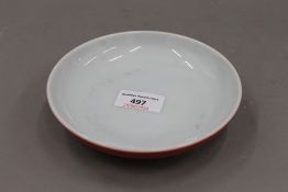 A Chinese red ground porcelain dish. 15 cm diameter.
