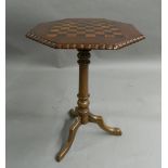 A Victorian inlaid tripod games table. 69.5 cm high.