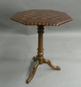 A Victorian inlaid tripod games table. 69.5 cm high.