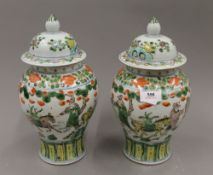 A pair of Chinese famille verte lidded vases, with four character mark to base. 28.5 cm high.
