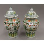 A pair of Chinese famille verte lidded vases, with four character mark to base. 28.5 cm high.