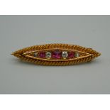 An unmarked gold diamond and ruby navette form brooch. 3.5 cm wide. 3.8 grammes total weight.