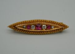 An unmarked gold diamond and ruby navette form brooch. 3.5 cm wide. 3.8 grammes total weight.