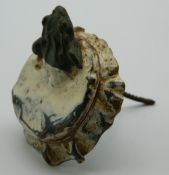 A cold painted bronze model of a frog, in a bottle top.