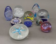 A collection of various glass paperweights