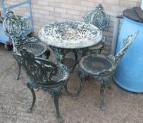 A Victorian cast iron pub table with associated top and a set of four cast iron garden chairs.