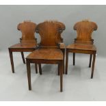 A set of four early 19th century mahogany hall chairs. 42.5 cm wide.