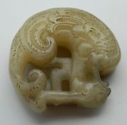 A Chinese carved jade roundel. 4.5 cm high.