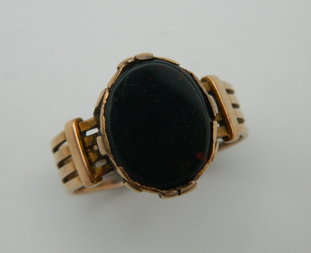 A 9 ct gold gentleman's signet ring set with blood stone. Ring Size U. 6.8 grammes total weight.