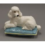 A Beswick model of a poodle on a cushion. 18 cm wide.