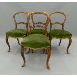 A set of four Victorian walnut balloon back chairs. 45 cm wide.