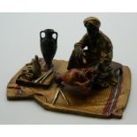 A cold painted bronze model of an Arab painting a pottery vase. 9 cm wide.