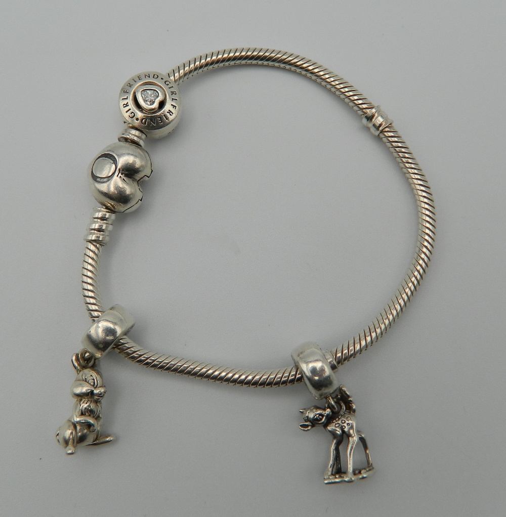 A Pandora silver bracelet and charms. 26.2 grammes. Approximately 16 cm long.