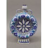 A Persian/Iznik pottery pierced moon flask. 25 cm high.