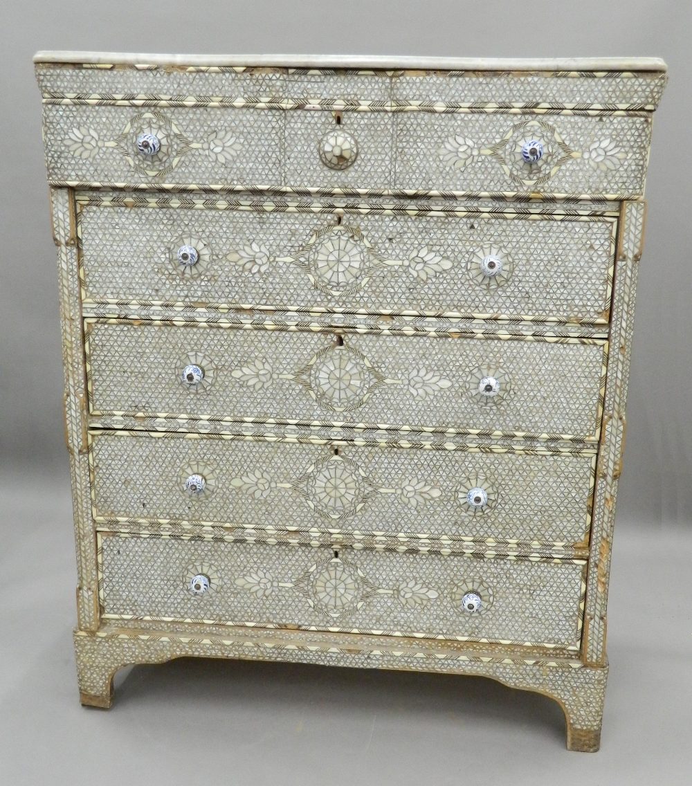 A Syrian mother-of-pearl inlaid chest of drawers with associated marble top.