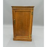 A leather topped oak pedestal side cabinet. 58.5 cm wide. The property of Germaine Greer.