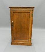 A leather topped oak pedestal side cabinet. 58.5 cm wide. The property of Germaine Greer.