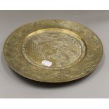 A Chinese brass plate. 27 cm diameter.