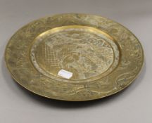 A Chinese brass plate. 27 cm diameter.