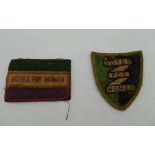 Two small Vote for Women suffragette type cloth patches, one shield shaped, the other rectangular.