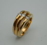 A 14 ct gold three stone diamond ring. Ring Size L/M. 9.5 grammes total weight.