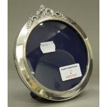 A circular silver photograph frame. 13 cm wide.