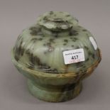 An Antique Chinese jade circular pedestal box and cover, finely carved with lappets. 15 cm high.