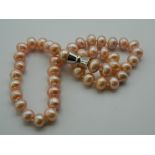 A pink pearl bead necklace. 46 cm long.