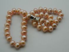 A pink pearl bead necklace. 46 cm long.