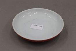 A Chinese red ground porcelain dish. 15 cm diameter.