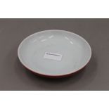 A Chinese red ground porcelain dish. 15 cm diameter.