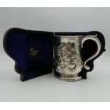 An embossed Georgian silver tankard, housed in a later case. 11 cm high. 9.1 troy ounces.