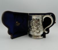 An embossed Georgian silver tankard, housed in a later case. 11 cm high. 9.1 troy ounces.