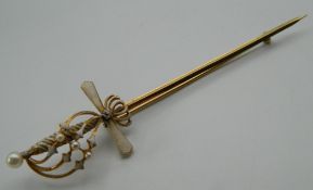 A 14 K gold and enamel sword brooch. 10 cm long. 5 grammes total weight.