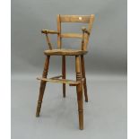 A Victorian elm seated child's highchair. 81.5 cm high. The property of Germaine Greer.