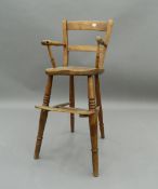 A Victorian elm seated child's highchair. 81.5 cm high. The property of Germaine Greer.