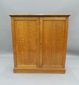 A Victorian oak two-door cupboard. 106.5 cm wide. The property of Germaine Greer.