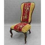 A Victorian rosewood framed tapestry covered nursing chair. 48 cm wide.