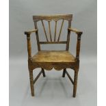 A Georgian elm solid seated country open armchair. 51.5 cm wide.