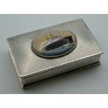A silver snuff box decorated with a steam liner. 8 cm wide.