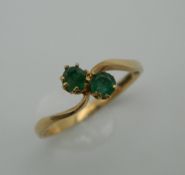 A 9 ct gold and emerald wishbone ring. Ring Size P. 1.4 grammes total weight.