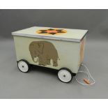 A wheeled wooden toy box. 72 cm long.